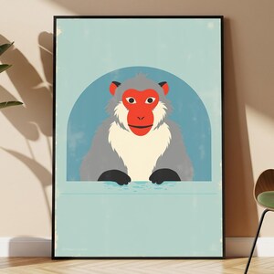 May include: A rectangular wall art print in a black frame featuring a stylized illustration of a Japanese macaque with a bright red face and grey fur, set against a light blue circular background on a pale blue field with a subtle distressed texture.
