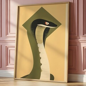 May include: A framed vertical wall art print featuring a stylised illustration of a cobra snake. The snake has a black head with a bright orange eye, a cream-coloured underbelly with dark triangular markings, and a dark olive green hood.
