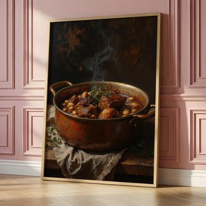 May include: A framed wall art print depicting a rustic copper pot filled with a steaming meat and bean stew. The dark, moody composition highlights the metallic texture of the cookware, the rich brown tones of the food, and wisps of rising steam.