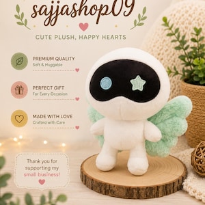 May include: A white plush angel doll with black accents, blue and green details, and mint green wings. The doll is displayed on a wooden slice. The text on the image says "sajjashop09" and "CUTE PLUSH, HAPPY HEARTS".