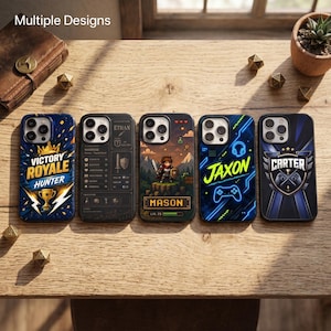 May include: Five smartphone cases featuring distinct gaming-themed designs. The cases display graphics including a trophy with the text Victory Royale Hunter, a character stat sheet for Ethan, a pixelated warrior named Mason, a neon Jaxon logo, and a Carter crest.