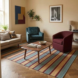 May include: A living room scene featuring a beige sofa, teal armchair, and burgundy swivel chair. A striped rug with teal, gold, and burgundy stripes sits beneath a wooden coffee table. Artwork and plants add decorative elements to the room.