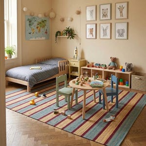 May include: A child's bedroom with a wooden bed, a round table, and two chairs. A striped rug in blue, yellow, and red covers the floor. Artwork of animals hangs on the wall. Toys and books are on the table and shelves.