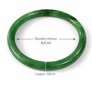 Könnte beinhalten: Ein glatter, kreisförmiger grüner Armreif mit polierter Oberfläche. Der Armreif hat einen Innendurchmesser von 6,0 cm und eine Breite von 0,8 cm, wie durch den Messwert und die Pfeile im Bild angegeben.
