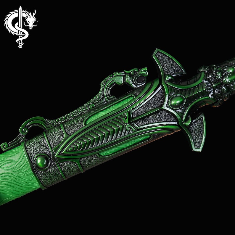 Pu&ograve; includere: Primo piano di una spada decorativa verde con intricati dettagli a tema drago. La spada presenta un'impugnatura e una guardia della lama strutturate, con un design a testa di drago sull'elsa. La lama ha un motivo strutturato.