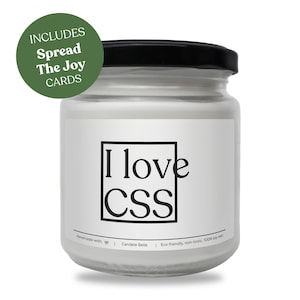 Peut inclure: Une bougie blanche dans un pot en verre transparent avec un couvercle noir. L'étiquette présente un cadre carré noir contenant le texte I love CSS. Un badge circulaire vert dans le coin supérieur gauche affiche le texte INCLUDES Spread The Joy CARDS.