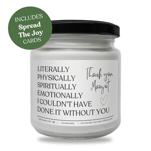 Puede incluir: Un frasco de vela de vidrio transparente con tapa negra y etiqueta blanca. La etiqueta incluye el texto: LITERALLY PHYSICALLY SPIRITUALLY EMOTIONALLY I COULDN'T HAVE DONE IT WITHOUT YOU, Thank you, Margot, y un corazón. Una insignia circular verde dice: INCLUDES Spread The Joy CARDS.