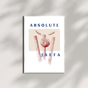 May include: A framed print featuring a sketch-style illustration of a cricket scene. The artwork includes a cricket ball, wickets, and the text "ABSOLUTE JAFFA" in blue, with the word "ABSOLUTE" above the image and "JAFFA" below.