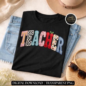 Może przedstawiać: Czarny t-shirt z napisem "TEACHER" w kolorowych, haftowanych literach. Litery mają różne wzory, w tym szachownicę, kropki i kratę vichy. Koszulka leży na parze niebieskich dżinsów.