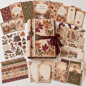 May include: A collection of autumn-themed stationery featuring a central journal with a leaf-patterned cover, lace trim, and a burgundy ribbon. Includes decorative cards, tags, stickers, and paper sheets with illustrations of pumpkins, birds, and foliage.