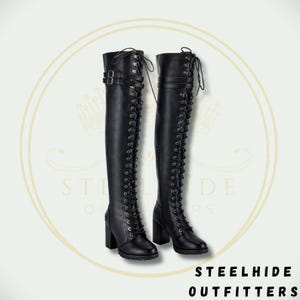 May include: A pair of black, over-the-knee boots with lace-up detailing and block heels. The boots feature buckles and a round toe design. The text "STEELHIDE OUTFITTERS" is visible at the bottom of the image.