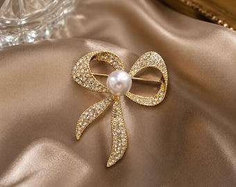 Vintage strikbroche, goudkleurig kristal en nepparelspeld, elegante statement-sieraden