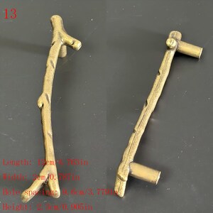 Puede incluir: Dos tiradores de armario de color bronce con dise&ntilde;o de ramita. Los tiradores miden 12 cm de largo, 3 cm de ancho y tienen una separaci&oacute;n entre agujeros de 9,6 cm. La altura es de 2,3 cm. El n&uacute;mero 13 est&aacute; en la esquina superior izquierda.