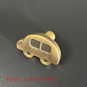 Puede incluir: Un tirador de armario de color bronce en forma de coche antiguo. El tirador tiene dos ventanas y dos ruedas. El ancho es de 3,8 cm (1,496 pulgadas) y la altura es de 2,1 cm (0,826 pulgadas).