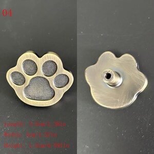 Puede incluir: Un pomo de armario con forma de huella de pata de color bronce. El pomo tiene forma de pata de perro o gato con cinco almohadillas. La parte posterior del pomo tiene un tornillo para la fijaci&oacute;n. Las dimensiones son 3,5 cm de largo, 4 cm de ancho y 1,5 cm de alto.