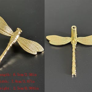 Puede incluir: Objeto decorativo dorado en forma de lib&eacute;lula. La lib&eacute;lula tiene alas y cuerpo detallados. Las dimensiones son: largo 6,5 cm, ancho 7,8 cm, alto 2,5 cm. El n&uacute;mero "11" est&aacute; en la esquina superior izquierda.