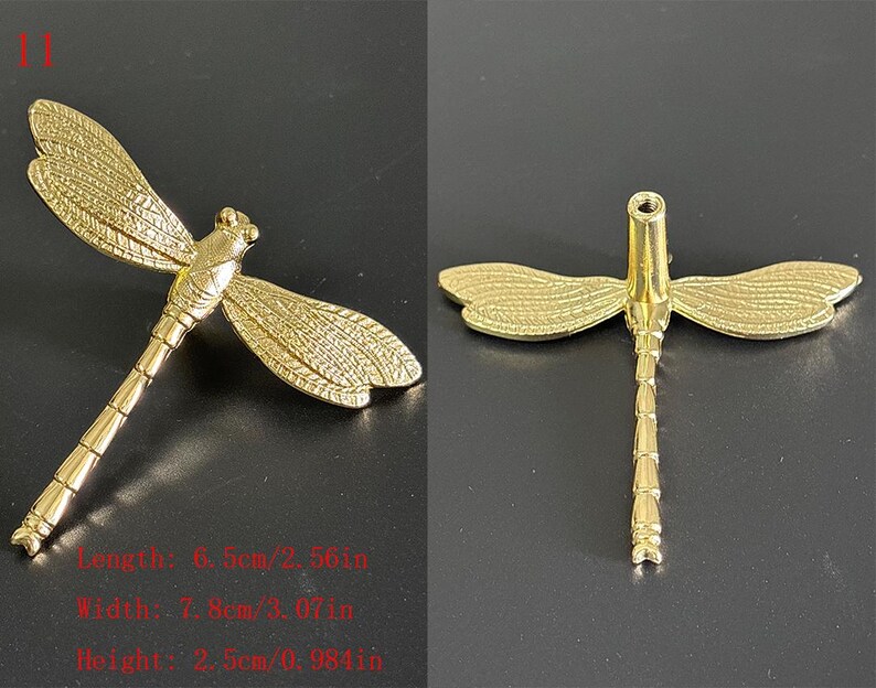 Puede incluir: Objeto decorativo dorado en forma de lib&eacute;lula. La lib&eacute;lula tiene alas y cuerpo detallados. Las dimensiones son: largo 6,5 cm, ancho 7,8 cm, alto 2,5 cm. El n&uacute;mero "11" est&aacute; en la esquina superior izquierda.