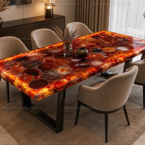 May include: A rectangular dining table featuring a polished surface made of translucent red and orange agate slices with a backlit effect. The table is supported by a black metal frame and is surrounded by four beige upholstered chairs.
