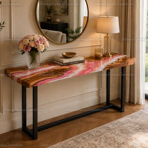May include: A rectangular console table featuring a natural wood slab top with a vibrant pink resin inlay running through the center. The table is supported by a black metal frame with two U-shaped legs, providing a sturdy base for the tabletop.