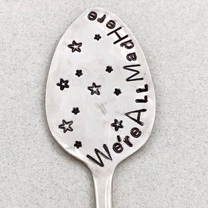 May include: A silver spoon with the words "We're All Made of Hope" engraved on it. The spoon is decorated with small star shapes.