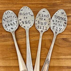May include: Four silver spoons with engraved sayings. The spoons read "It's Parsley My Fault", "Mint To Bee", "Kind Of A Big Dill", and "Thyme For Me To Fly".