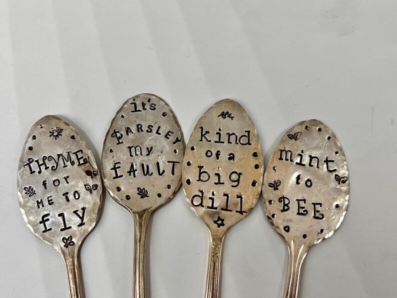 May include: Four silver spoons with engraved sayings about herbs. The spoons read "It's Parsley my Fault", "Thyme for me to fly", "Kind of a big dill", and "Mint to be".