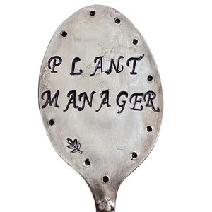 Garden marker made from recycled silver plate spoon flattened and hand stamped with the words ‘Plant Manager’ with decorative dots and stamps.