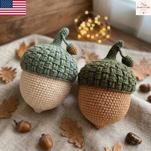 Puede incluir: Dos decoraciones de bellotas tejidas a ganchillo con sombreros texturizados de aspecto tejido en verde salvia y verde oliva. Las secciones inferiores son lisas, redondeadas y de color beige claro y tostado. Cada bellota tiene un tallo curvo.