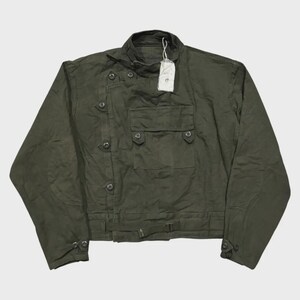 May include: Olive green jacket with multiple button closures, two front pockets, and a small collar. The jacket has a belt detail at the waist and a tag attached. A stylish outerwear piece.