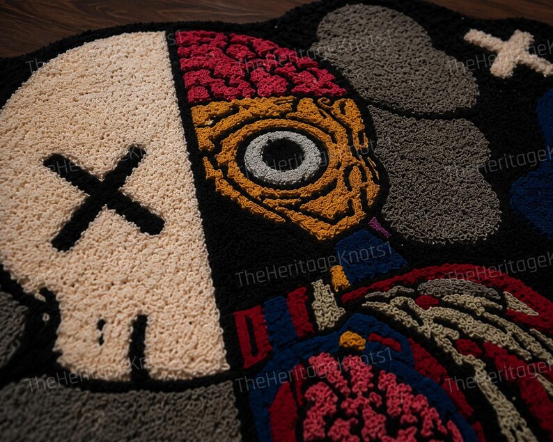 May include: A black, beige, red, and blue tufted rug with a skull and anatomical design. The skull has a black 'X' for eyes. The other side of the rug features an eye and brain design. The rug is made of a soft, textured material.