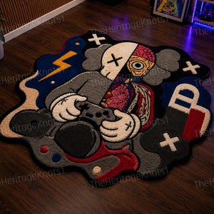 May include: A distinctive, custom-made rug with a cartoon character design. The rug depicts a figure holding a game controller, with a dissected anatomical design. The color scheme includes grey, black, red, blue, and white, creating a striking visual.