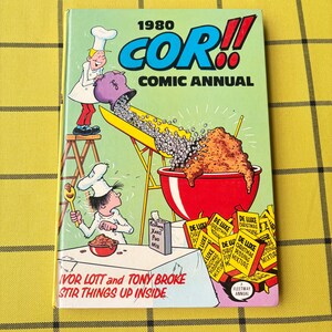 May include: The 1980 COR!! Comic Annual features a light green cover with a cartoon illustration of two chefs preparing a large red bowl of pudding. The text reads 1980 COR!! COMIC ANNUAL and IVOR LOTT and TONY BROKE STIR THINGS UP INSIDE.