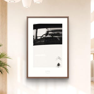 May include: A framed black and white wall art print featuring a close-up view of a vintage car interior, including the steering wheel and dashboard, with the Citroen logo visible on the lower right side of the white border area.
