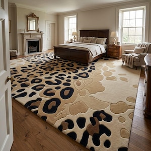 Könnte beinhalten: Ein großer Teppich mit einem markanten Leopardenmuster in Beige-, Hellbraun- und Schwarztönen. Der Teppich bedeckt den Großteil des Holzhodens in einem Schlafzimmer und zeigt ein sich wiederholendes Tiermuster mit strukturierten, erhabenen Details.