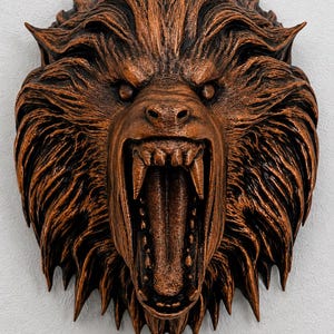 May include: A wall-mounted sculpture of a snarling werewolf head with a copper-toned finish. The creature features a wide-open mouth revealing sharp teeth, a long tongue, and detailed fur textures radiating outward from the center of the face.