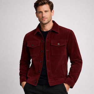 May include: A burgundy corduroy jacket with two chest pockets and button closures. The jacket has a classic collar and is worn over a black shirt. The jacket is a stylish outerwear option.