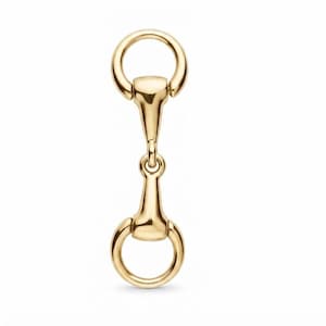 May include: A polished gold-tone metal horse bit connector featuring a vertical bar design with two circular rings at the top and bottom. The hardware has a smooth, reflective surface and a symmetrical structure, commonly used as a decorative accent.