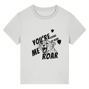 Op de afbeelding: Lichtgrijs t-shirt met een zwart-witte illustratie van een brullende luipaard. De tekst "YOU'RE GOING TO HEAR ME ROAR" is in het zwart gedrukt, wat een opvallend contrast creëert.