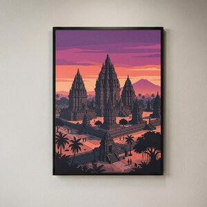 May include: A framed wall art print depicting a multi-tiered stone temple complex at sunset. The scene features dark grey architectural structures, palm trees, and small figures against a vibrant sky of purple, orange, and soft pink hues.