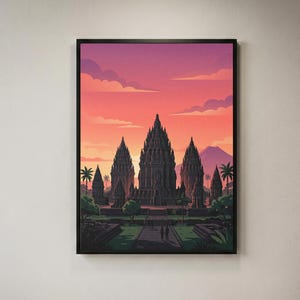 Op de afbeelding: Een ingelijste kunstprint met een gestileerde illustratie van het Prambanan-tempelcomplex bij zonsondergang. De scène toont donkere stenen tempelspitsen tegen een levendige lucht met kleurverlopen in oranje, roze en paarse tinten.