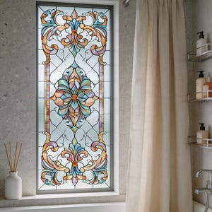 Könnte beinhalten: Ein rechteckiges Buntglasfenster mit einem floralen und scrollartigen Design in Orange-, Blau- und Lilatönen. Das Fenster ist in einem grauen Rahmen gefasst und befindet sich in einem Badezimmer. Rechts hängt ein beigefarbener Vorhang.