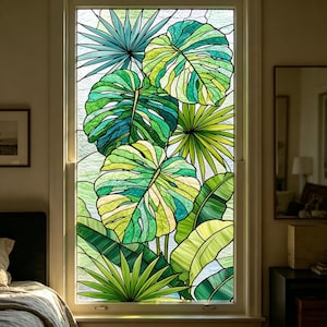 Könnte beinhalten: Ein Buntglas-Fensterpaneel mit einem lebendigen botanischen Design aus verschiedenen tropischen Blättern in Smaragd-, Limetten- und Waldgrüntönen. Die Glasteile sind durch dunkle Bleilinien verbunden und bilden ein detailliertes Muster aus Monstera- und Palmenblättern.