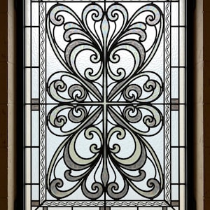 Könnte beinhalten: Ein rechteckiges Fenster mit einem schwarzen Metallrahmen und einem komplizierten Schnörkeldesign. Die Glasscheiben sind strukturiert und durchscheinend und zeigen ein symmetrisches Muster aus geschwungenen Linien und Schleifen.