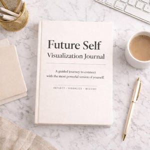 Puede incluir: Un diario color crema titulado "Future Self Visualization Journal" con el texto "A guided journey to connect with the most powerful version of yourself." Un bolígrafo dorado y una taza de café están junto al diario.