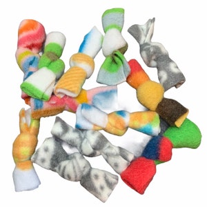 May include: A collection of colorful fleece dog toys in various shapes and patterns. The toys are tied in knots and are designed for chewing and playing.
