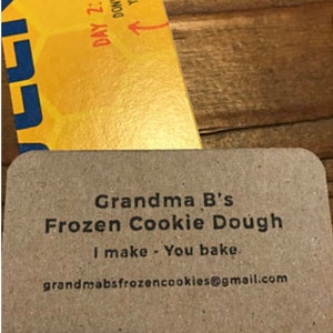 May include: A brown card with the text "Grandma B's Frozen Cookie Dough I make - You bake." and the email address "grandmabsfrozencookies@gmail.com".