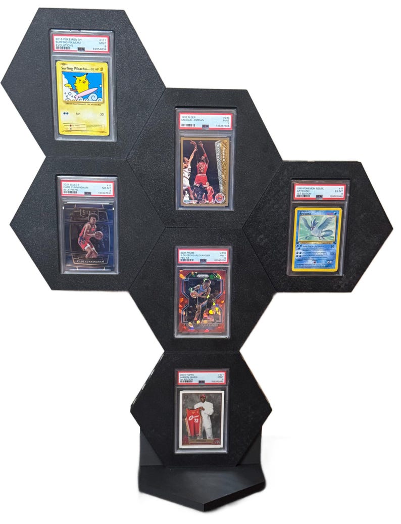 Op de afbeelding: Zwart zeshoekig display met zes beoordeelde ruilkaarten. De kaarten bevatten afbeeldingen van atleten en stripfiguren. Het display is ontworpen om verzamelkaarten te presenteren.