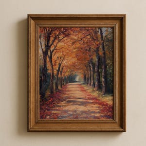 Puede incluir: Pintura enmarcada de un paisaje otoñal. Un camino bordeado de árboles con hojas naranjas y rojas crea un efecto túnel. El marco es de color marrón medio y cálido.