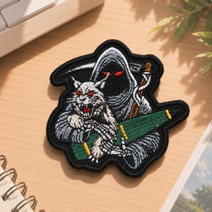 May include: A black embroidered patch featuring a hooded figure in a grey robe with glowing red eyes, holding a scythe. The figure is embracing a snarling white lynx with red eyes. A green bottle with yellow accents is positioned across the lower section.
