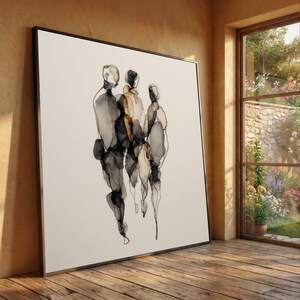 Könnte beinhalten: Abstrakter Kunstdruck mit drei Figuren in Schwarz- und Neutraltönen. Das Kunstwerk ist in einem schwarzen Rahmen gerahmt und lehnt an einer Wand. Die Figuren werden mit fließenden Linien und aquarellartigen Effekten dargestellt, wodurch eine moderne Ästhetik entsteht.
